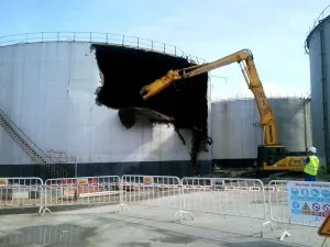 Excavadora demoliendo un depósito industrial
